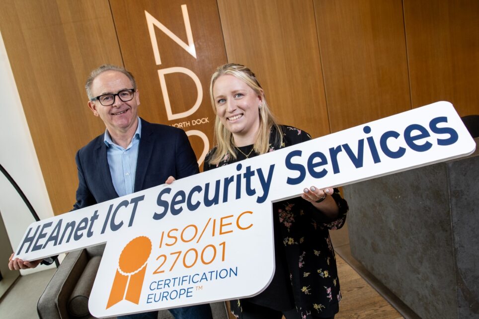 Man and woman holding promotional sign